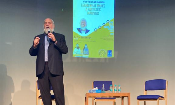 Dr. Eric Zackrison delivering a keynote presentation on leadership and management to a live audience.